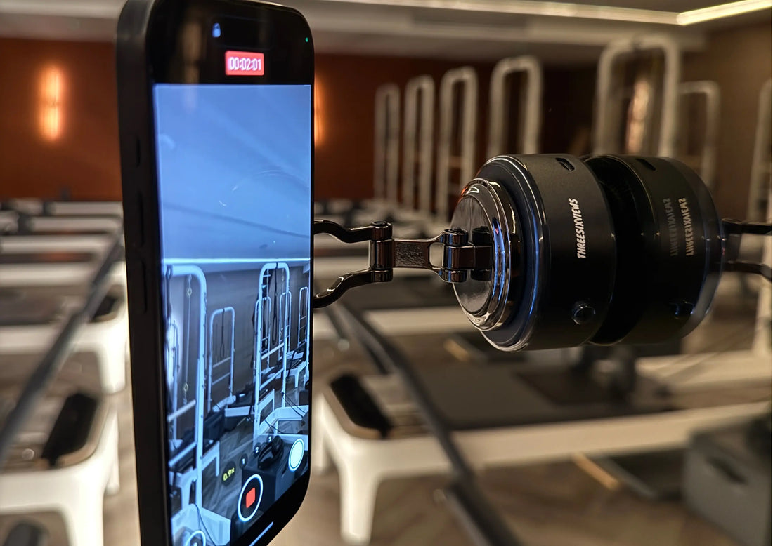 The Smart Vacuum Mount stuck to a studio mirror, holding a phone that is recording